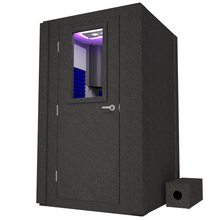 Load image into Gallery viewer, Front view of WhisperRoom&#39;s Voice Over Basic Package - a 4&#39; x 4&#39; single-wall vocal booth, complete with acoustic treatment, a functional desk, studio lighting, and various additional features. The left-hinged door is closed, with the interior elegantly adorned in vibrant blue StudioFoam.
