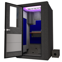 Load image into Gallery viewer, An inviting view of WhisperRoom&#39;s Voice Over Basic Package - a 4&#39; x 4&#39; single-wall vocal booth. The booth is thoughtfully equipped with acoustic treatment, a well-organized desk, professional studio lighting, and additional features. The image captures the booth at an angle from the front with its left-hinged door open, revealing the vibrant blue StudioFoam interior.
