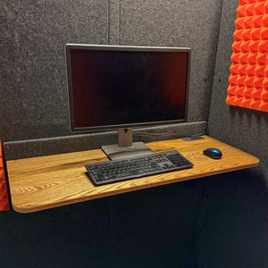 WhisperRoom's larger Office Desk shown with a monitor, keyboard, and mouse on its spacious surface.