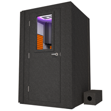 Load image into Gallery viewer, Front view of WhisperRoom&#39;s Voice Over Basic Package - a 4&#39; x 4&#39; single-wall vocal booth, meticulously designed with acoustic treatment, a functional desk, studio lighting, and an array of premium features. The left-hinged door is closed, and the interior is adorned with vibrant orange StudioFoam, creating an ideal recording environment.
