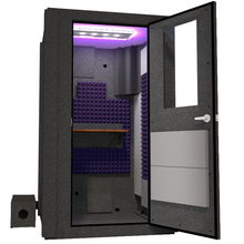 Load image into Gallery viewer, Angled view of WhisperRoom&#39;s Voice Over Basic Package - a 4&#39; x 4&#39; single-wall vocal booth, meticulously equipped with acoustic treatment, a functional desk, studio lighting, and an array of premium features. The right-hinged door is open, revealing the interior adorned with elegant purple StudioFoam, creating an inviting and professional recording space.
