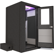 Load image into Gallery viewer, Side view of the WhisperRoom&#39;s Voice Over Basic Package - a 4&#39; x 4&#39; single-wall vocal booth, featuring acoustic treatment, a functional desk, studio lighting, and an array of premium features. The right-hinged door is open, revealing the interior accented with sleek gray StudioFoam, creating an ideal recording space.
