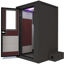 Load image into Gallery viewer, Side view of the WhisperRoom&#39;s Voice Over Deluxe Package - a 4&#39; x 4&#39; double-wall vocal booth, thoughtfully equipped with acoustic treatment, a functional desk, studio lighting, and an array of premium features. The left-hinged door is open, revealing the interior enhanced by sophisticated burgundy StudioFoam, creating an ideal recording atmosphere.
